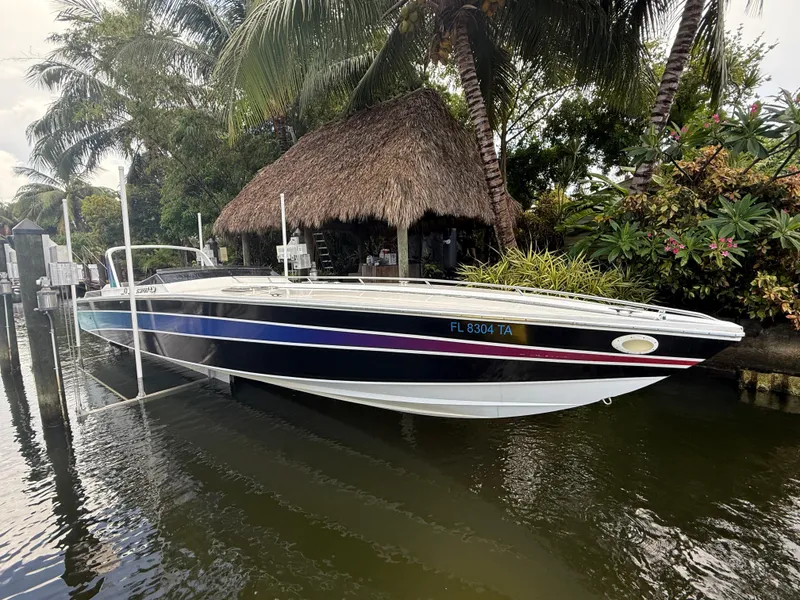 Slide: The Image of 1988 Wellcraft Scarab 38 KV boat docked near tropical foliage and a thatched hut. - 3