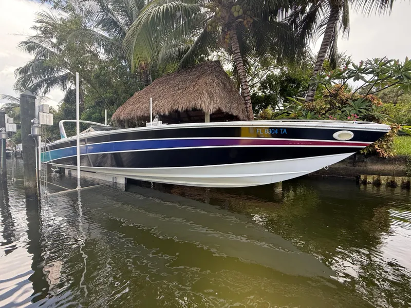 Slide: The Image of 1988 Wellcraft Scarab 38 KV boat docked near tropical foliage and water. - 4