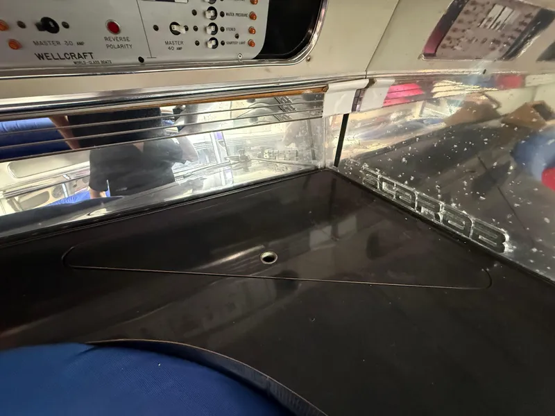 Slide: The Image of 1988 Wellcraft Scarab 38 KV control panel with reflective surfaces and visible branding. - 42