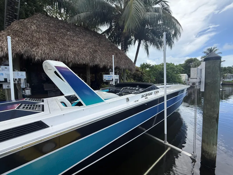 Slide: The Image of 1988 Wellcraft Scarab 38 KV boat docked near tropical palm trees. - 5