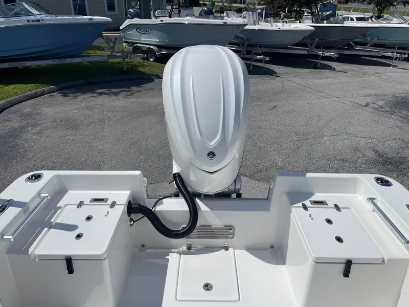 Slide: The Image of 2026 Bay Rider 269 Bay boat with outboard motor, parked in a marina. - 12