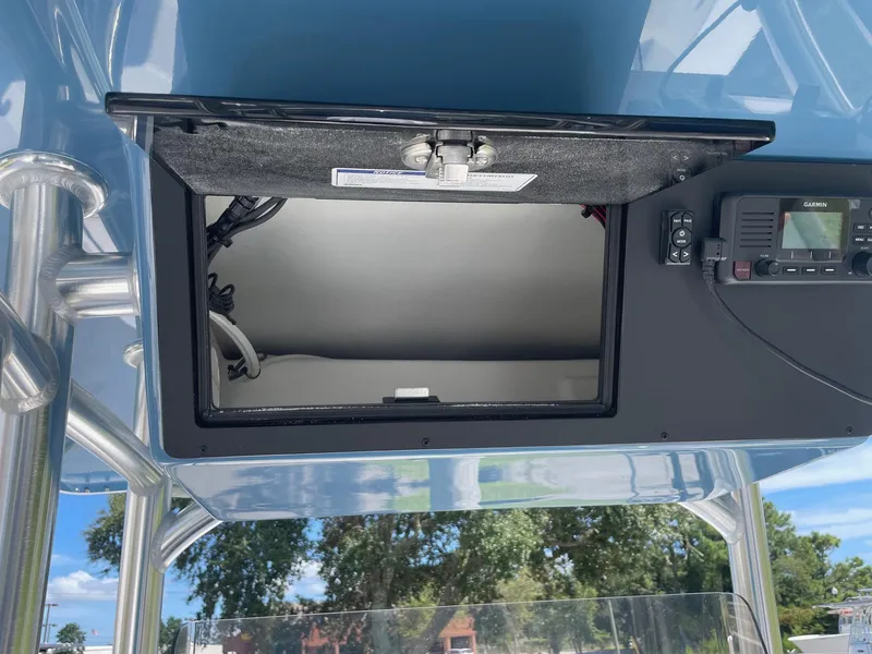 Slide: The Image of Open storage compartment on 2026 Bay Rider 269 Bay boat with electronic equipment. - 22