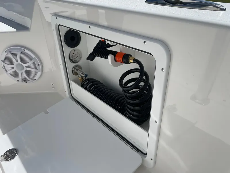 Slide: The Image of 2026 Bay Rider 269 Bay boat compartment with coiled hose and speaker. - 24