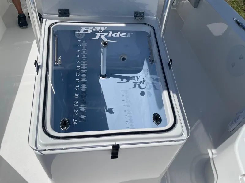 Slide: The Image of Bay Rider 269 Bay 2026 livewell with measurement markings and secure latch. - 26