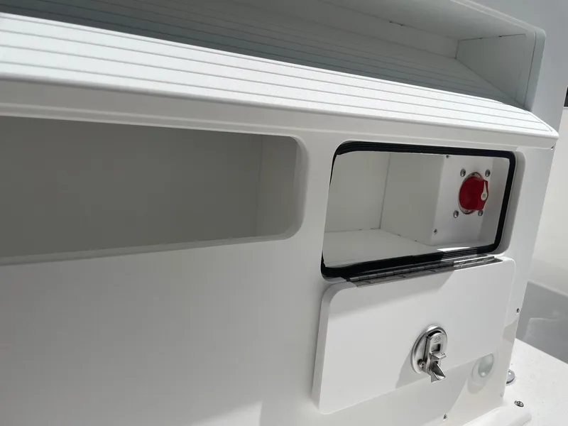 Slide: The Image of 2026 Bay Rider 269 Bay boat compartment with red switch and lock. - 36