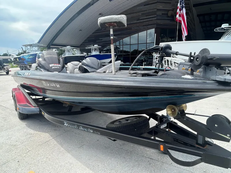 Slide: The Image of 2004 Triton Tr-20XDC boat on trailer, parked outdoors near modern building. - 2