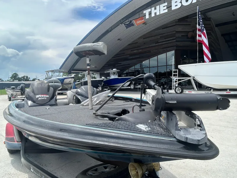 Slide: The Image of 2004 Triton Tr-20XDC boat displayed outside a showroom with American flag. - 6