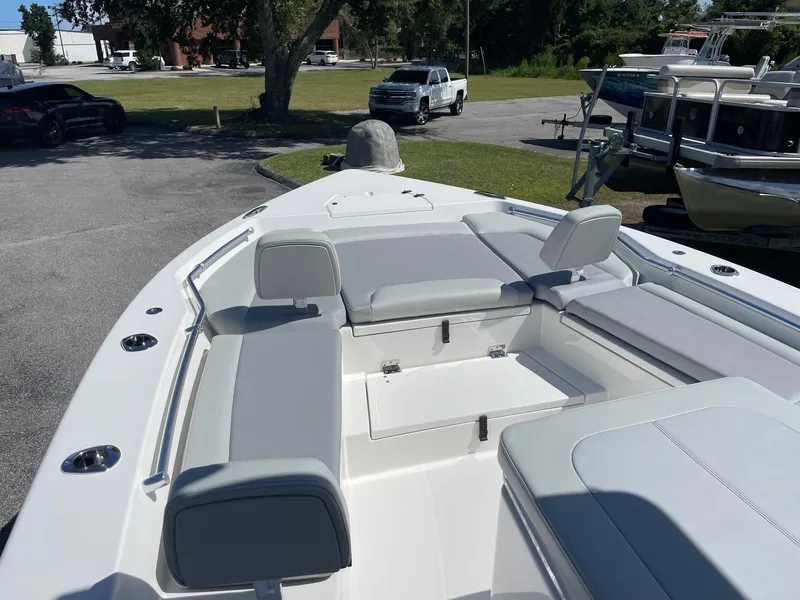 Slide: The Image of 2026 Bay Rider 269 Bay boat with spacious seating and sleek design in a parking area. - 7