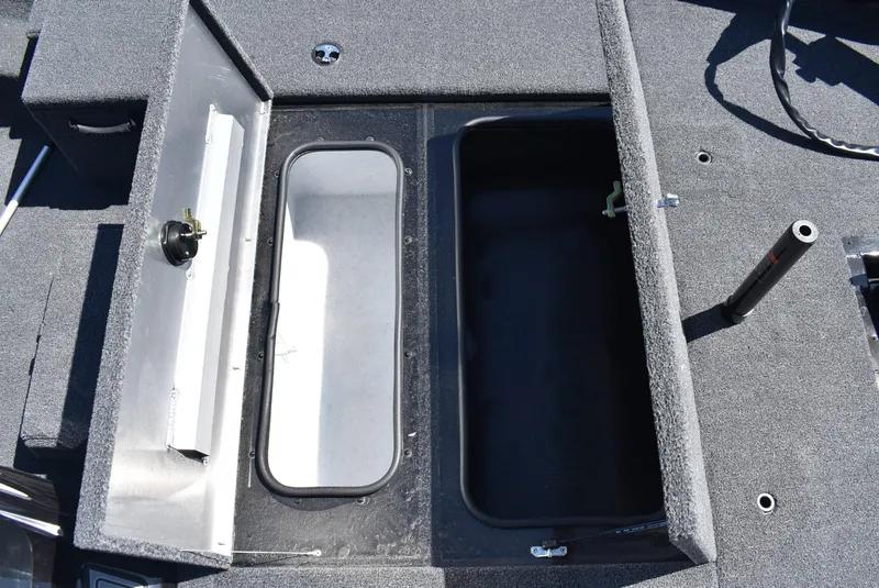 Slide: The Image of 2025 Lowe Stinger 175 boat interior storage compartments, featuring carpeted surfaces and open hatches. - 17