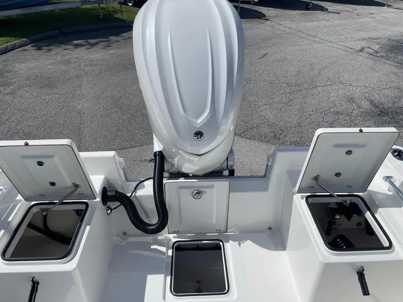 Slide: The Image of 2026 Bay Rider 269 Bay boat with open storage compartments and outboard motor. - 13