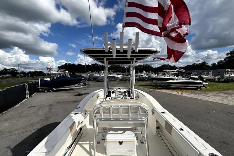 Slide: The Image of 2017 Robalo R200 Center Console boat with American flag, parked in a marina under cloudy sky. - 11