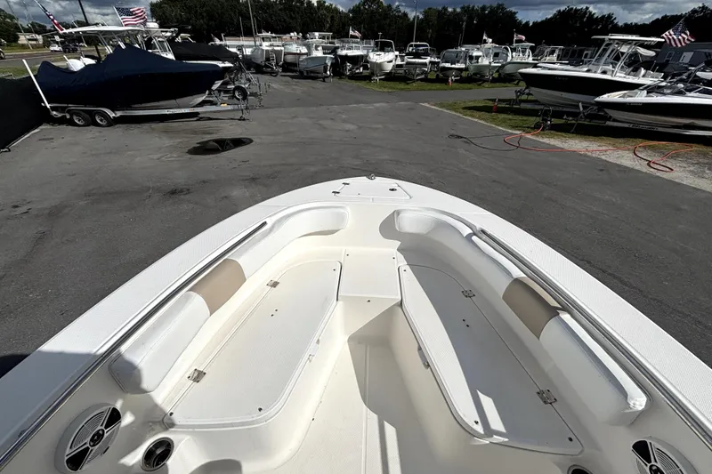 Slide: The Image of 2017 Robalo R200 Center Console boat interior with seating, in a marina setting. - 23