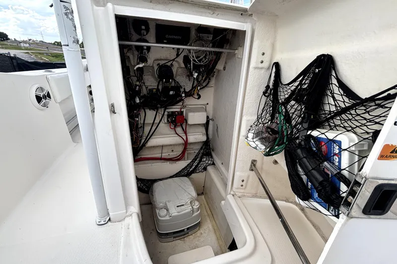 Slide: The Image of 2017 Robalo R200 Center Console storage compartment with wiring and equipment. - 32