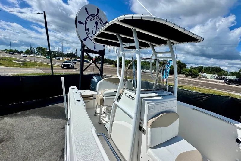 Slide: The Image of 2017 Robalo R200 Center Console boat with T-top, parked near highway. - 33