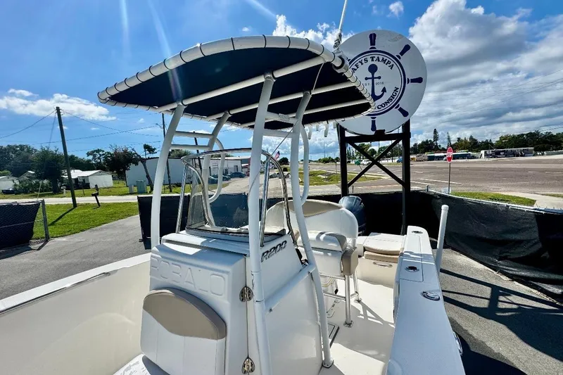 Slide: The Image of 2017 Robalo R200 Center Console boat with T-top, parked outdoors under a sunny sky. - 34