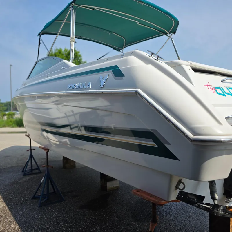 Slide: The Image of 1998 Formula 33 Super Sun Sport boat with green canopy on stands. - 12