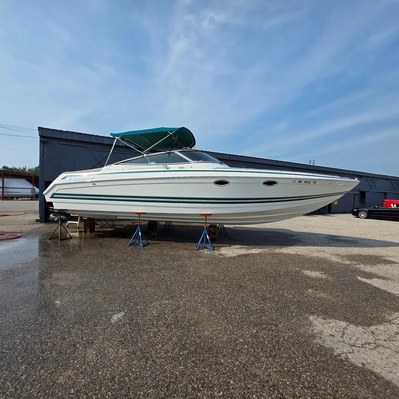 Slide: The Image of 1998 Formula 33 Super Sun Sport boat on stands, outdoor storage, clear sky. - 13