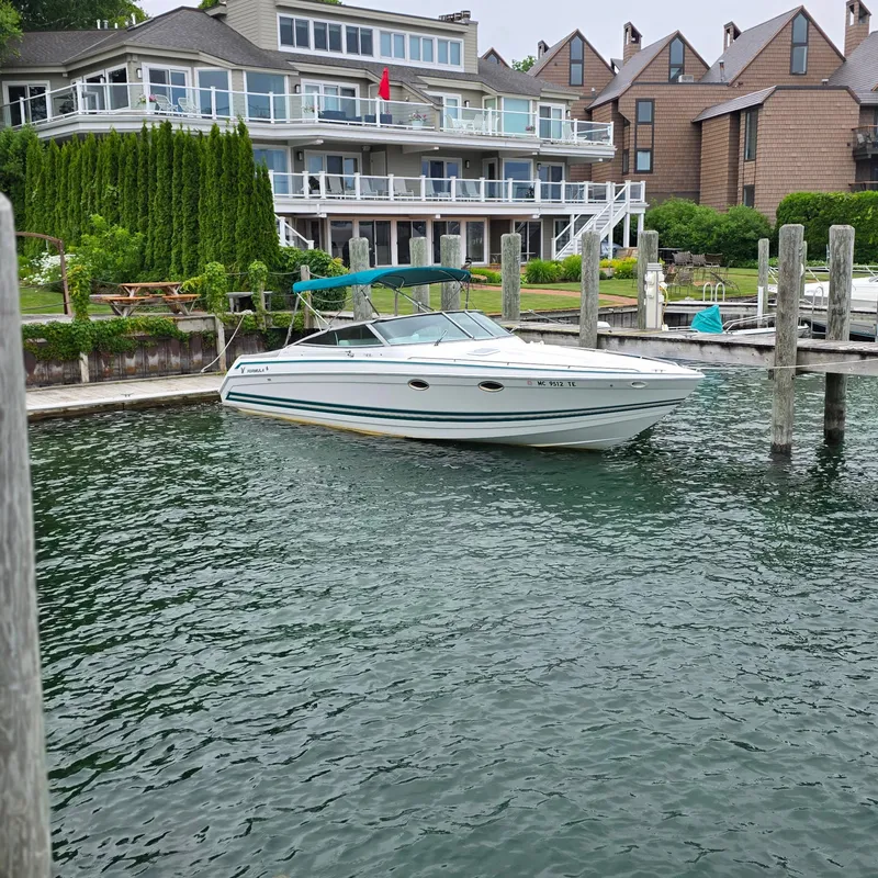 Slide: The Image of 1998 Formula 33 Super Sun Sport boat docked near waterfront homes. - 2