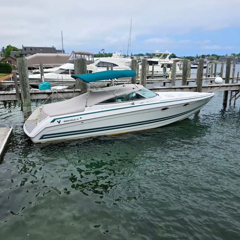 Slide: The Image of 1998 Formula 33 Super Sun Sport boat docked in a marina with teal canopy. - 3