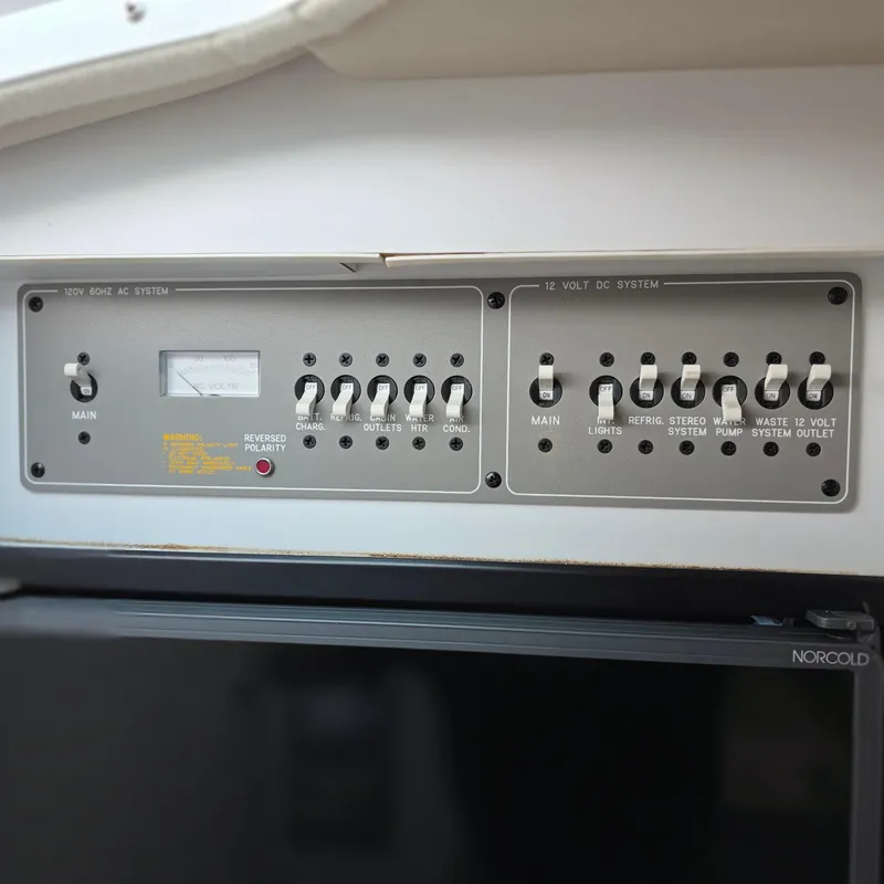 Slide: The Image of Control panel of a 1998 Formula 33 Super Sun Sport boat, featuring switches and voltage meter. - 37