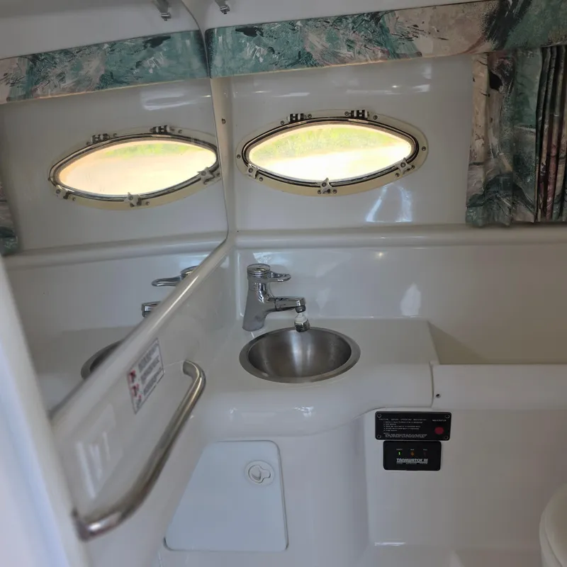 Slide: The Image of 1998 Formula 33 Super Sun Sport boat interior with sink and porthole windows. - 38