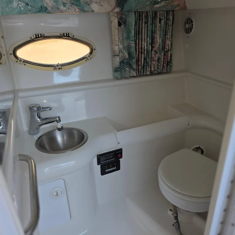 Slide: The Image of 1998 Formula 33 Super Sun Sport boat bathroom with sink, toilet, and porthole window. - 40