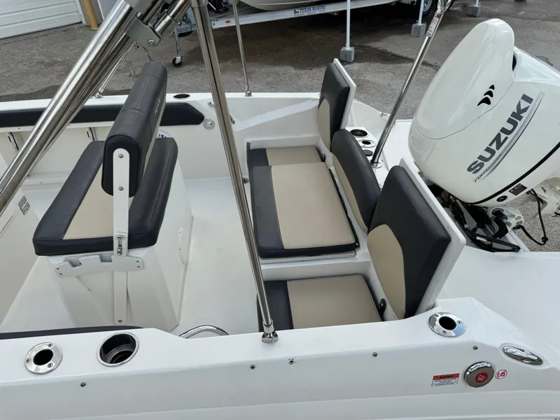 Slide: The Image of 2019 Stingray 186 CC boat interior with Suzuki outboard motor, featuring cushioned seating and stainless steel fixtures. - 18