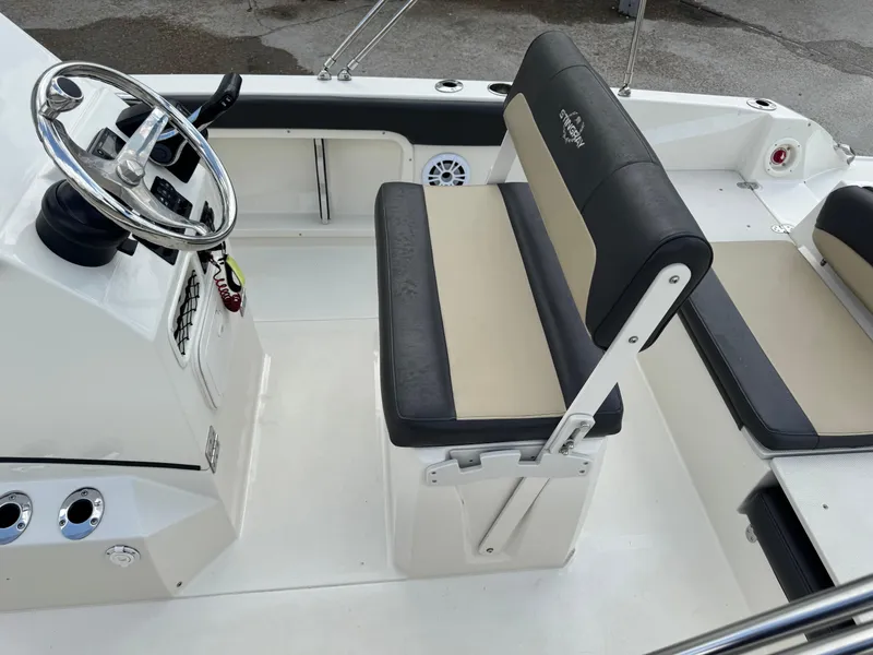 Slide: The Image of 2019 Stingray 186 CC boat interior with steering wheel and cushioned seating. - 23