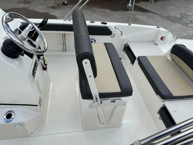 Slide: The Image of 2019 Stingray 186 CC boat interior with steering wheel and cushioned seating. - 25
