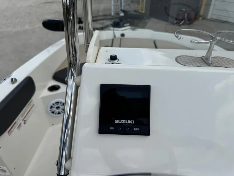 Slide: The Image of 2019 Stingray 186 CC boat dashboard with Suzuki display and cup holder. - 27