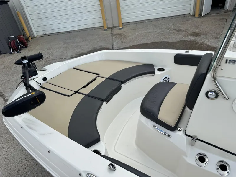 Slide: The Image of 2019 Stingray 186 CC boat interior with cushioned seating and trolling motor. - 31