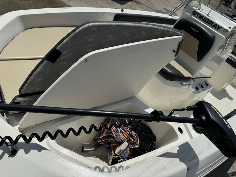 Slide: The Image of 2019 Stingray 186 CC boat interior with storage compartment and Minn Kota trolling motor. - 34