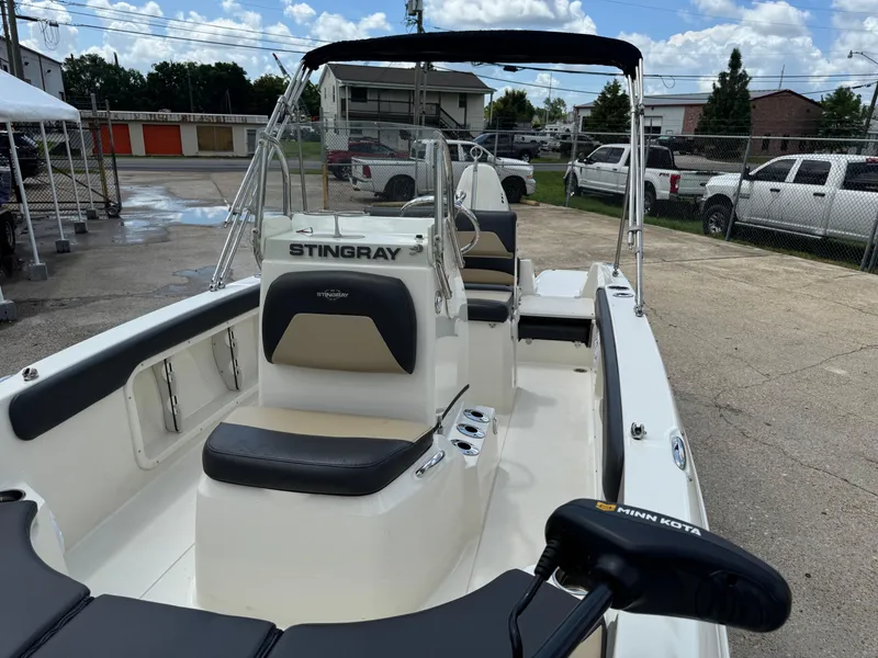 Slide: The Image of 2019 Stingray 186 CC boat with seating and Minn Kota motor in a parking area. - 36