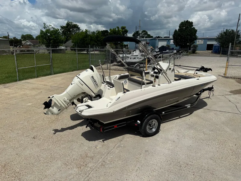 Slide: The Image of 2019 Stingray 186 CC boat with Suzuki outboard motor on a trailer, parked outdoors. - 40