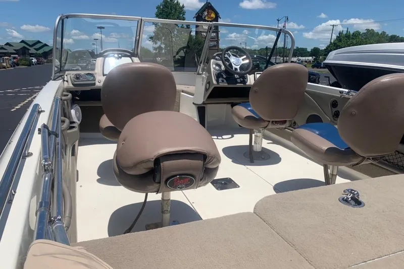 Slide: The Image of 2008 Ranger 1850VS boat interior with beige seats and steering console under a clear sky. - 4