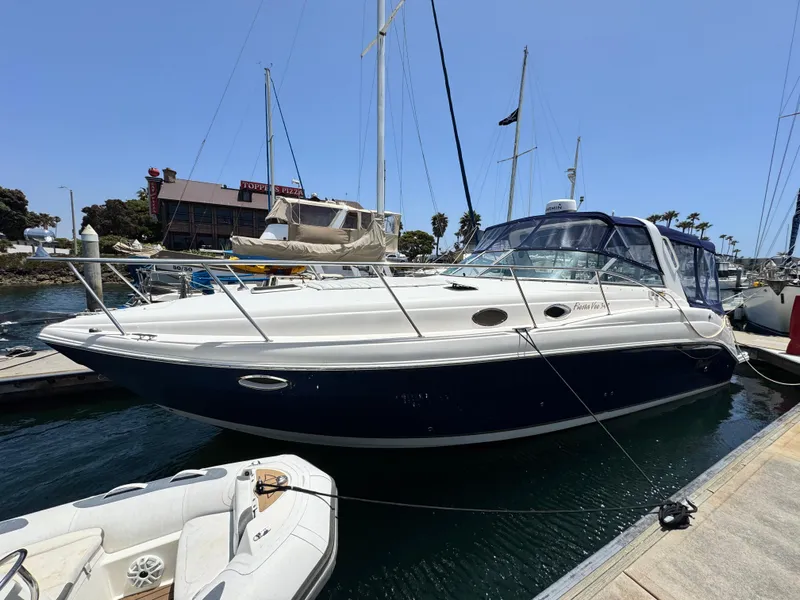 The Image of 2005 Rinker Fiesta Vee 342 yacht docked at marina, clear sky, nearby boats visible. - 0