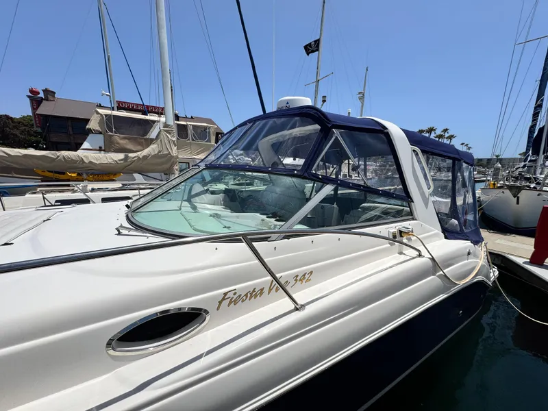 Slide: The Image of 2005 Rinker Fiesta Vee 342 boat docked at marina under clear blue sky. - 2