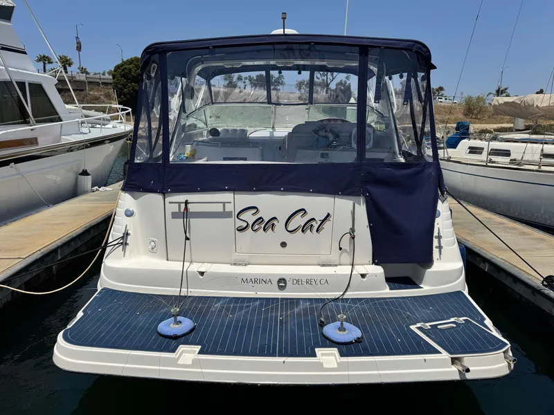 Slide: The Image of 2005 Rinker Fiesta Vee 342 boat docked at marina, rear view with blue canopy. - 3