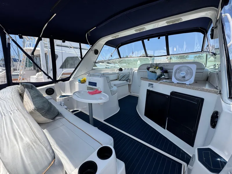 Slide: The Image of 2005 Rinker Fiesta Vee 342 interior with seating, table, and fan under a canopy. - 4