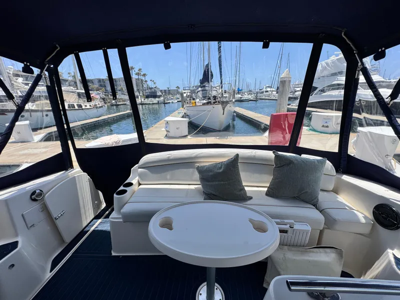 Slide: The Image of Interior view of 2005 Rinker Fiesta Vee 342 yacht at marina, featuring seating and table. - 5