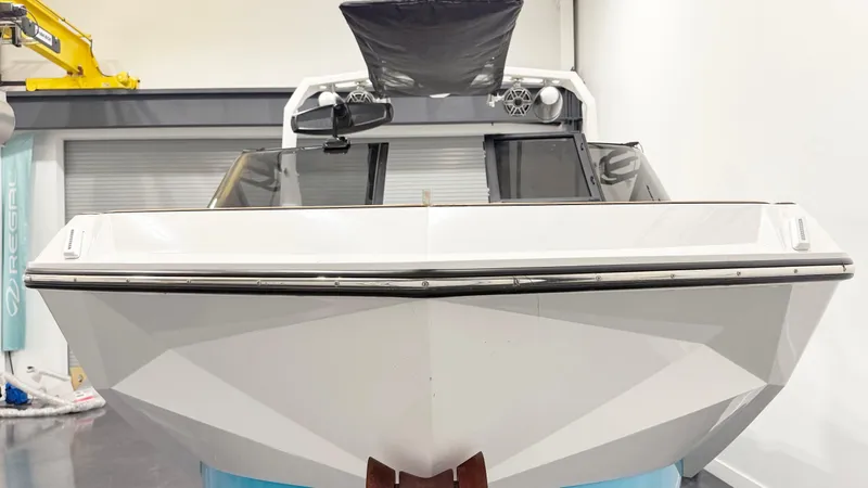 Slide: The Image of 2022 Nautique G23 boat in showroom, front view, sleek design. - 5