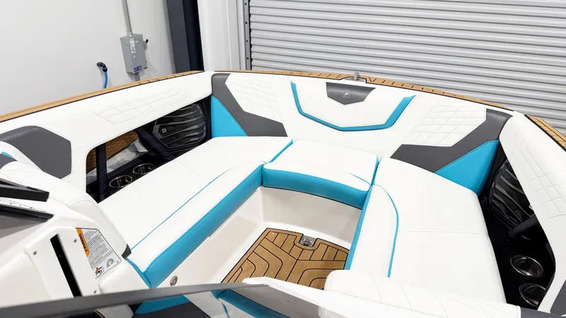 Slide: The Image of 2022 Nautique G23 boat interior with white and blue seating, wood flooring. - 9