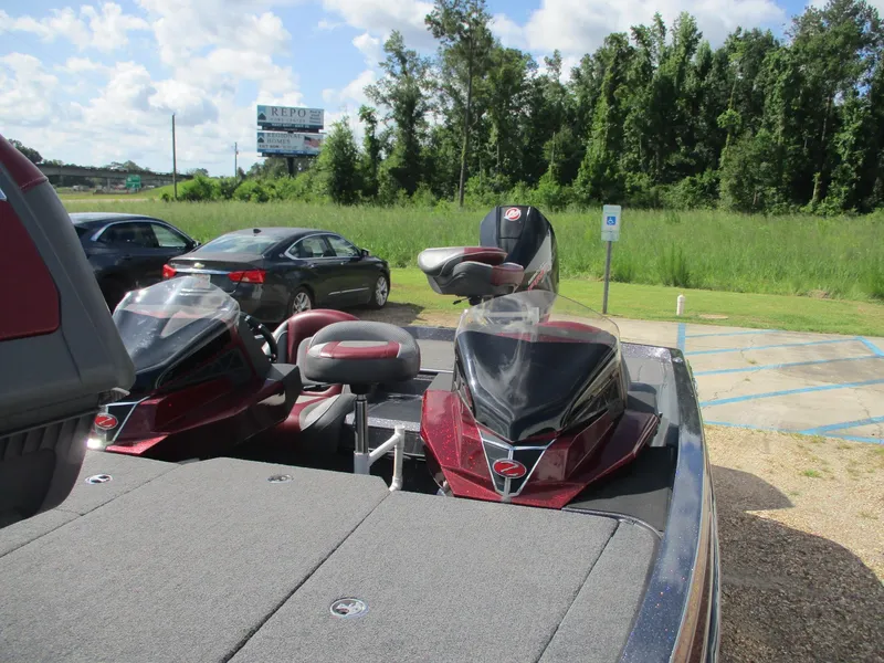 Slide: The Image of 2019 Ranger Z519L boat with dual consoles, parked near a grassy area and cars. - 11