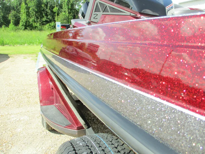 Slide: The Image of 2019 Ranger Z519L boat with sparkling red finish, parked outdoors. - 2