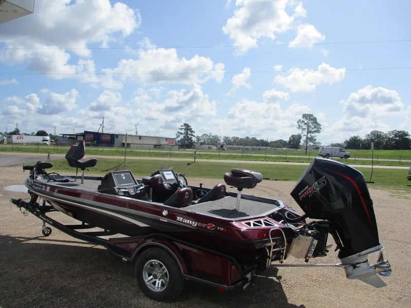 Slide: The Image of 2019 Ranger Z519L boat with motor, parked outdoors under a partly cloudy sky. - 3