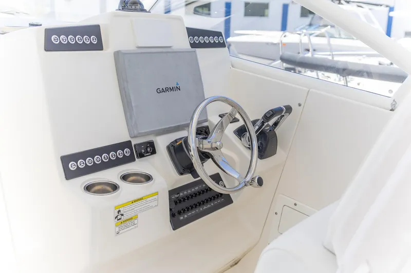 Slide: The Image of Edgewater 280 CX 2015 boat dashboard with Garmin navigation system and steering wheel. - 18