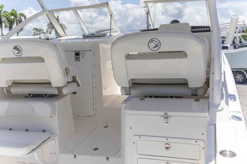 Slide: The Image of 2015 Edgewater 280 CX boat interior with white seating and dashboard. - 2