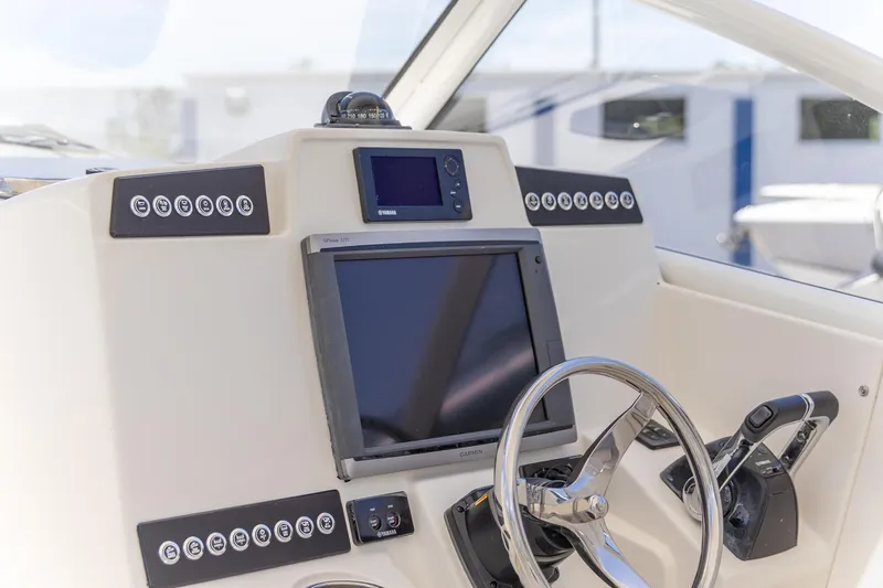 Slide: The Image of Control panel of a 2015 Edgewater 280 CX boat with steering wheel and navigation screens. - 21