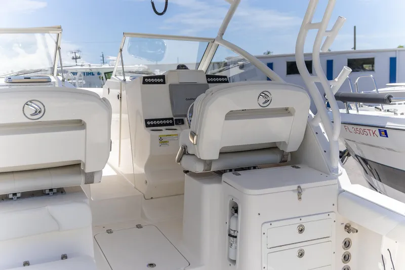 Slide: The Image of 2015 Edgewater 280 CX boat interior with helm and seating, featuring Garmin electronics. - 25
