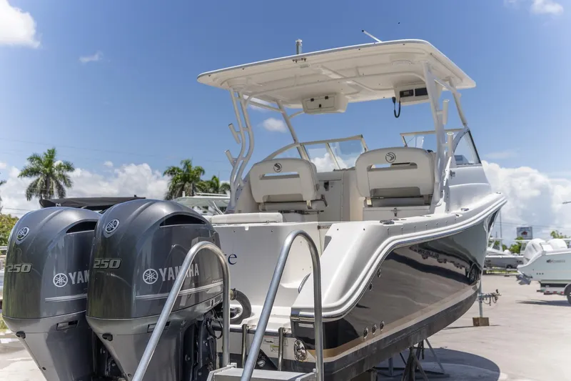 Slide: The Image of 2015 Edgewater 280 CX boat with twin Yamaha 250 engines, docked under a clear blue sky. - 26